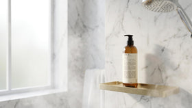 Santal 33 bottle placed on bathroom shelf conveying spa-like, elevated shower experience