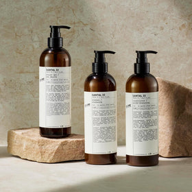 Santal 33 bottle in hotel-style shower evoking luxury hospitality scent atmosphere