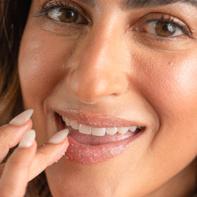 sara happ applying scrub to lips as part of routine benefit: preps lips for balm