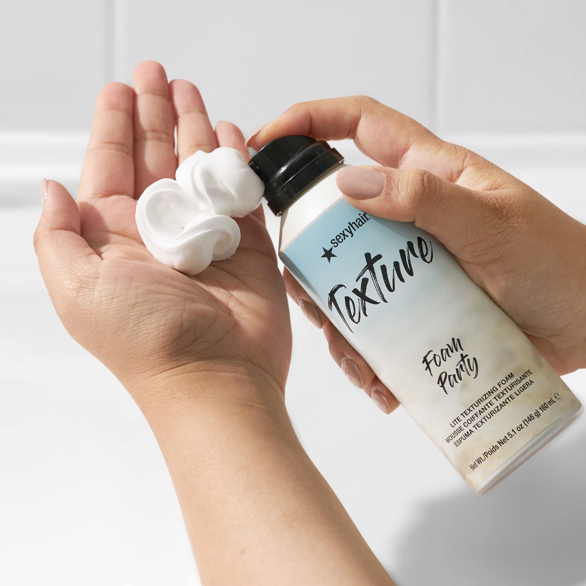 SexyHair foam dispensed on hand highlighting airy foam texture and control