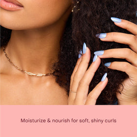 Shea Moisture oil applied to hands demonstrating easy spread