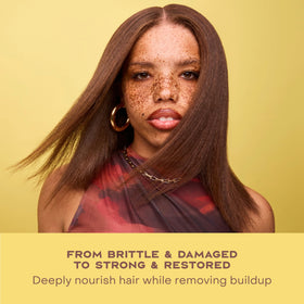 SheaMoisture bottle staged with shea butter and castor oil ingredients
