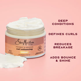 SheaMoisture jar beside coconut and hibiscus highlighting natural ingredients