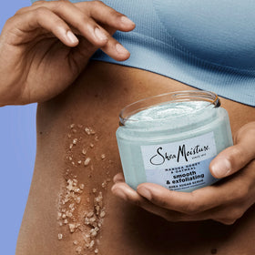 SheaMoisture next to a hand for 12 oz size comparison offering scale clarity