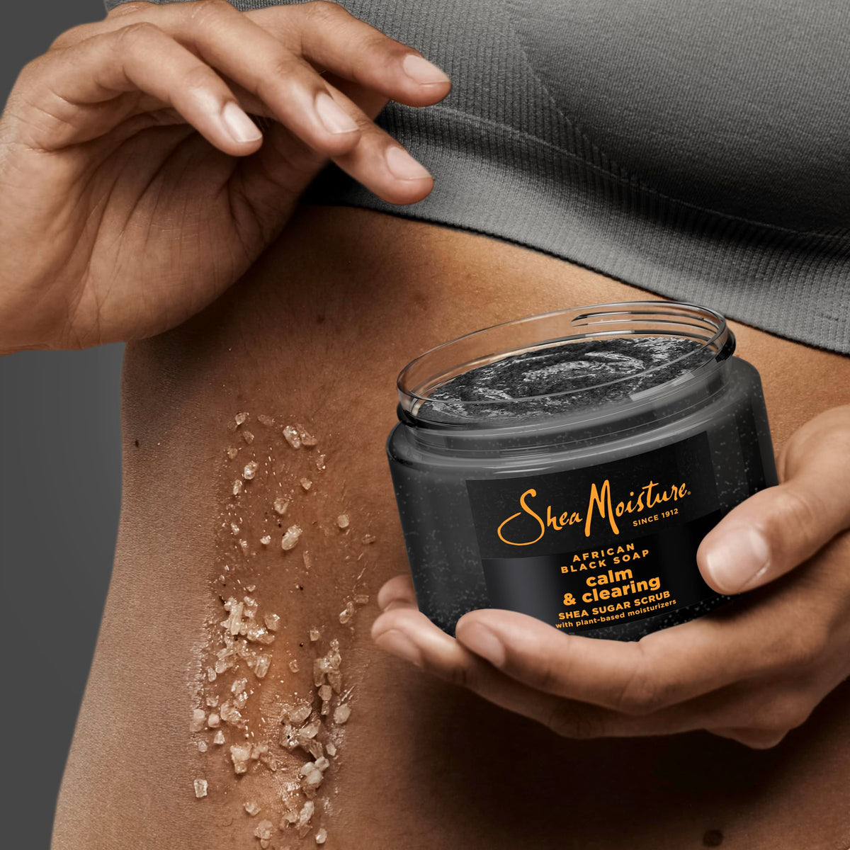 SheaMoisture 12 oz jar in hand indicating size and easy at-home use