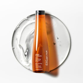 shu uemura art of hair bottle in hand showing 10 fl oz scale and convenience