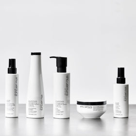 shu uemura art of hair bottle on shower shelf in lifestyle setting suggesting routine
