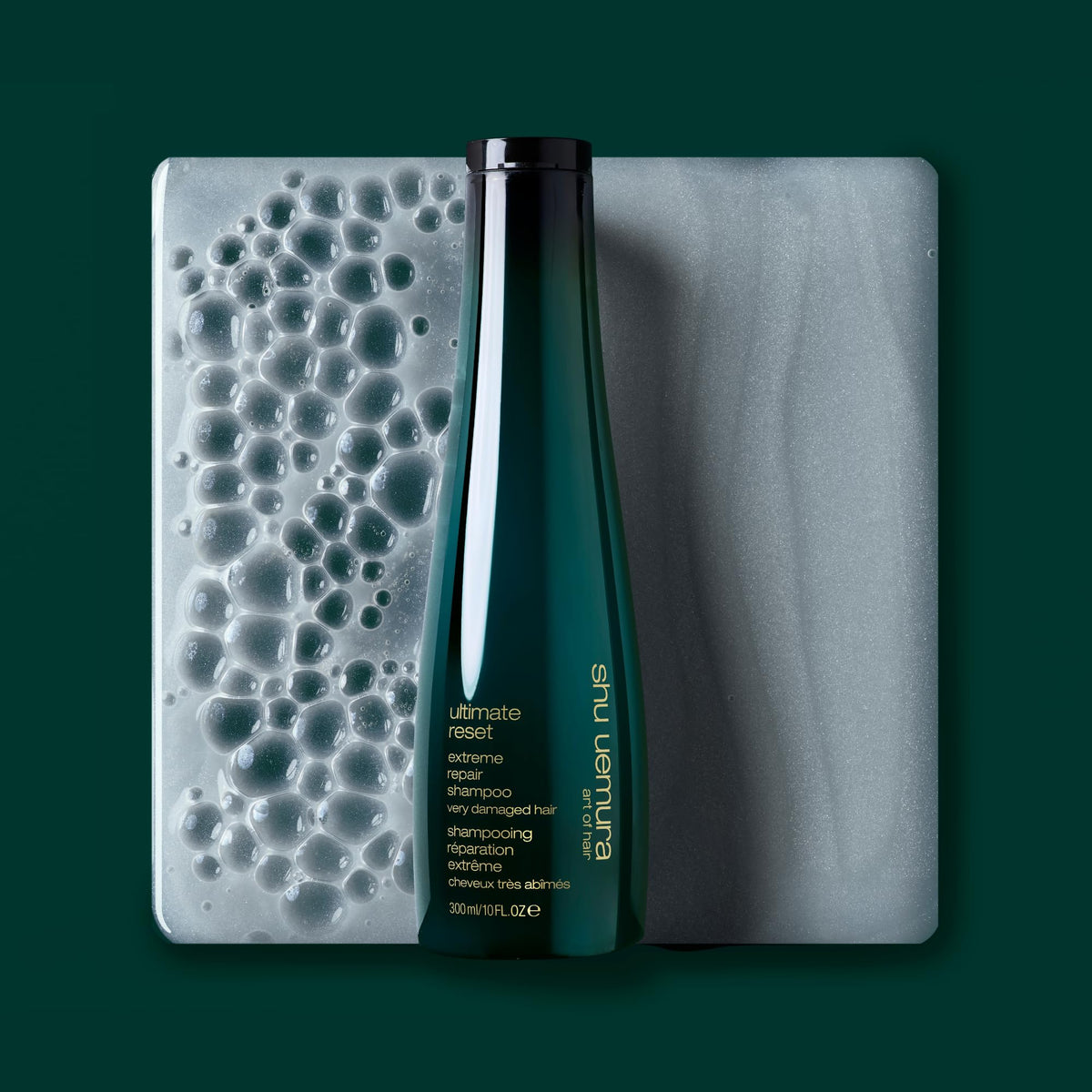 shu uemura art of hair bottle held in hand showing size and travel-friendly benefit