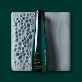 shu uemura art of hair bottle held in hand showing size and travel-friendly benefit