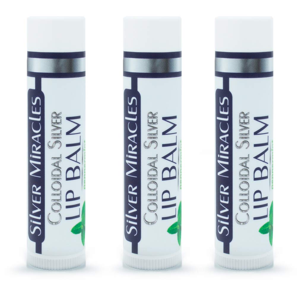 Person applying Silver Miracles lip balm tube to lips outdoors demonstrating portable hydration benefit