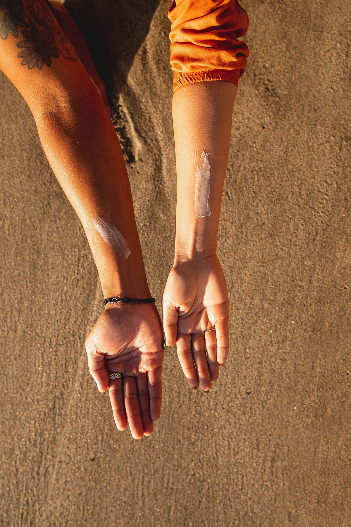 Skinnies on beach towel showing reef-safe sunscreen for ocean-friendly outings benefit