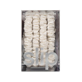 Slip scrunchie beside coin for size comparison illustrating slim profile