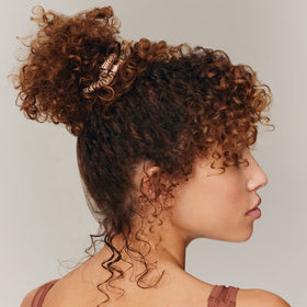 SLIP scrunchie securing a low bun while protecting hair from breakage