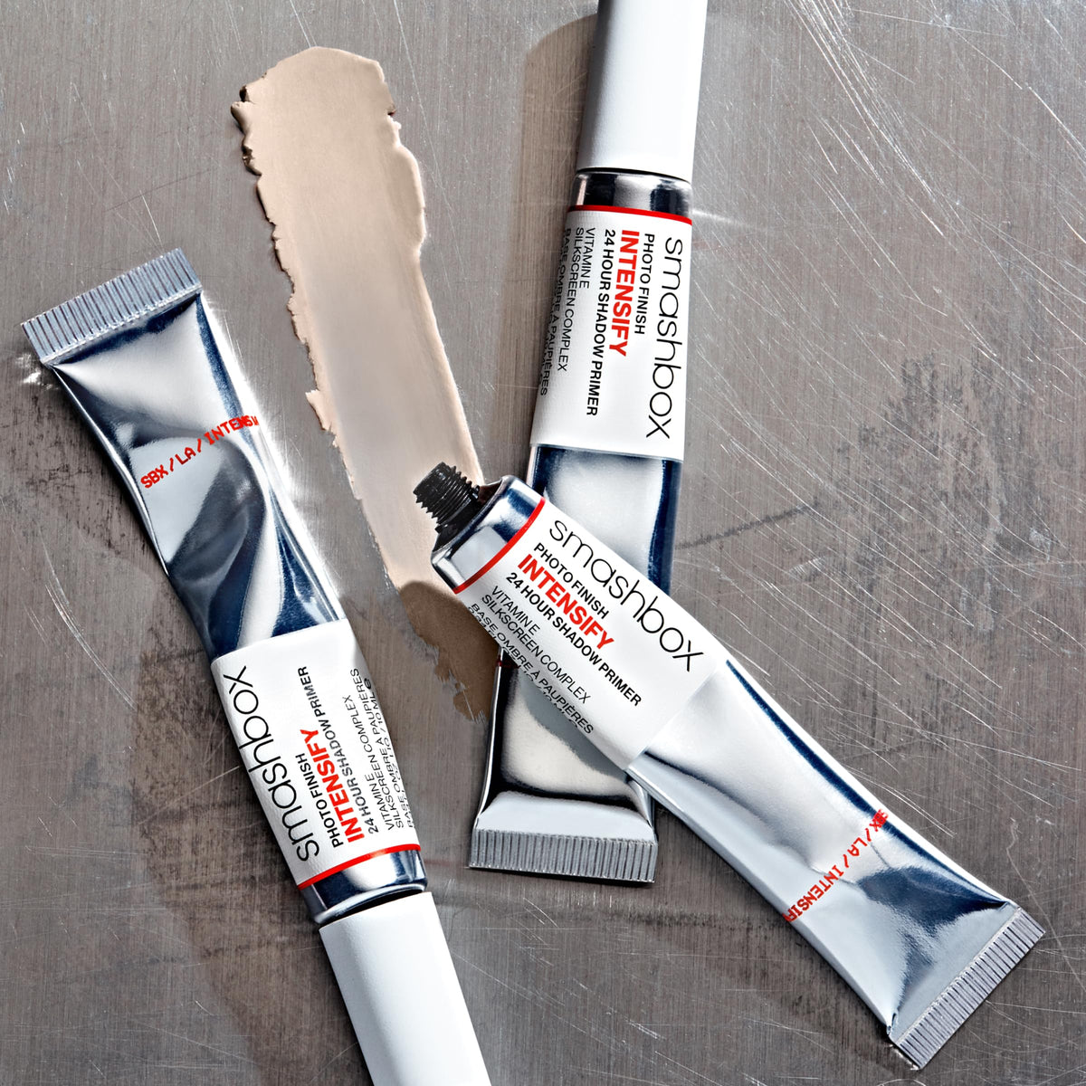 Size comparison of Smashbox 0.34 fl oz primer next to makeup brushes to show travel-friendly portability