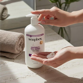 Soapbox bottle next to hand for size comparison and travel-friendly convenience