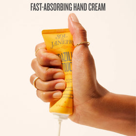 Sol de Janeiro cream being rubbed into hands, demonstrates quick non-greasy absorption