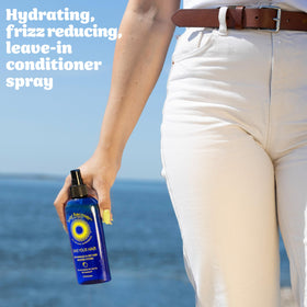 Solar Recover bottle on sand near ocean illustrating outdoor hair protection