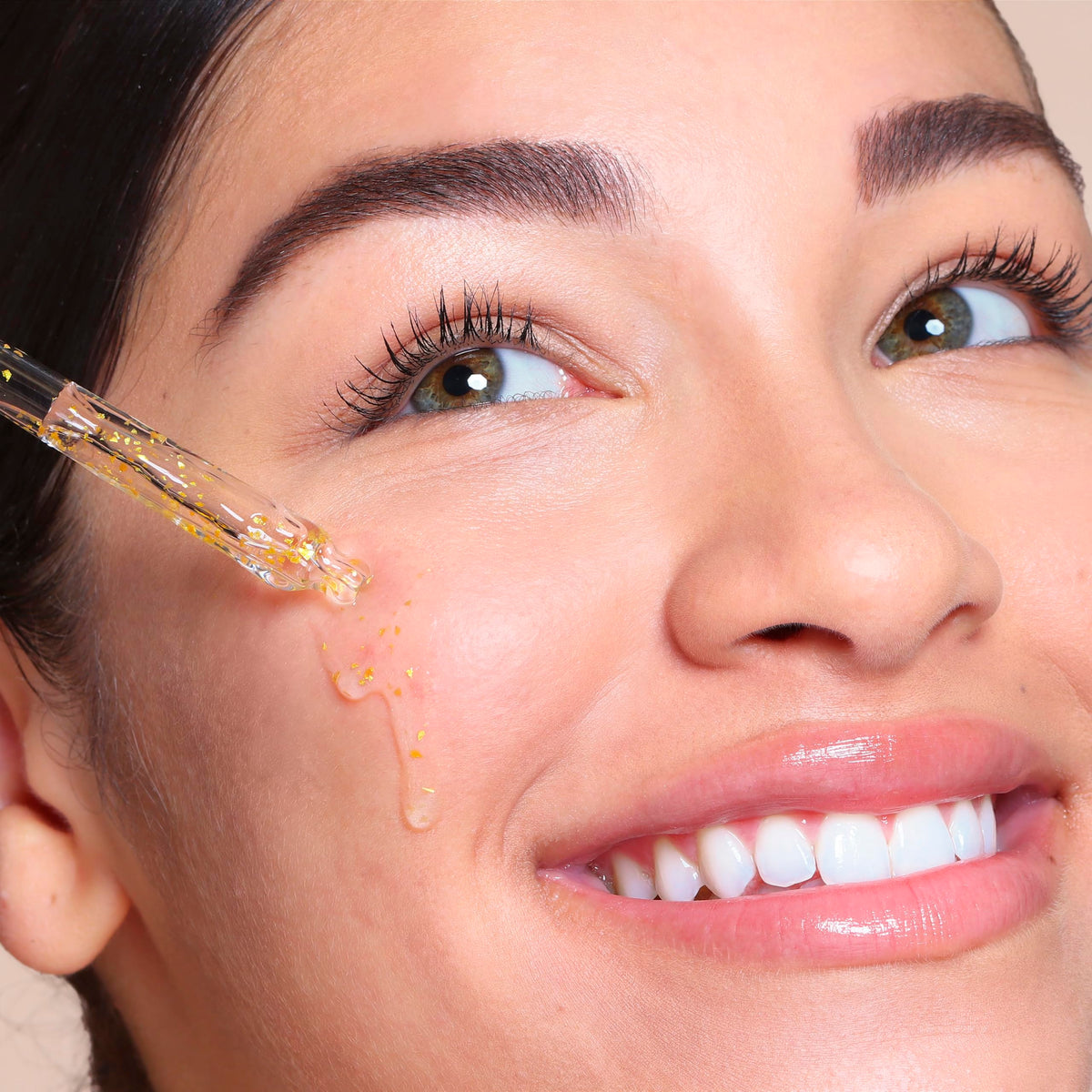 SpaLife close-up of 24k gold flakes suspended in serum for luminous glow