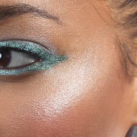 stila product styled with makeup bag showing travel-friendly, versatile highlighting benefit
