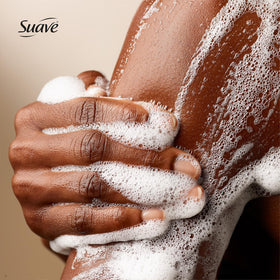 Hand holding a 30 oz Suave bottle to show scale and long-lasting use