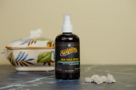 Sea salt and charcoal ingredients near Suavecito bottle highlighting cleansing benefits