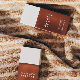 Summer Fridays on vanity with towel and plant, evoking effortless daily routine benefit