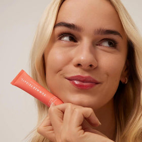 Summer Fridays swatch on forearm displaying sheer coral poppy tint and subtle shine benefit