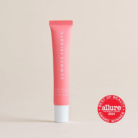 Summer Fridays tube on a makeup vanity showing layering over lipstick benefit