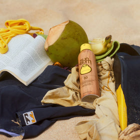 Sun Bum applied at beach scene illustrating water-resistant protection benefit