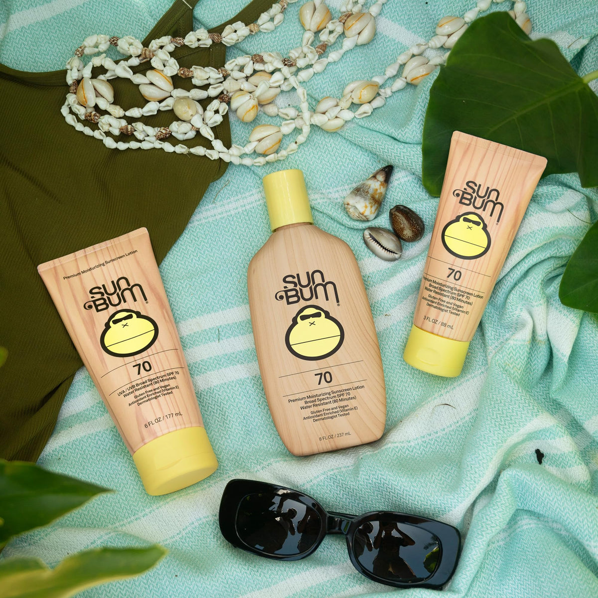 Sun Bum 8 oz bottle next to sunglasses for scale and travel-friendly sun protection