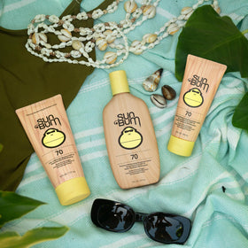 Sun Bum 8 oz bottle next to sunglasses for scale and travel-friendly sun protection