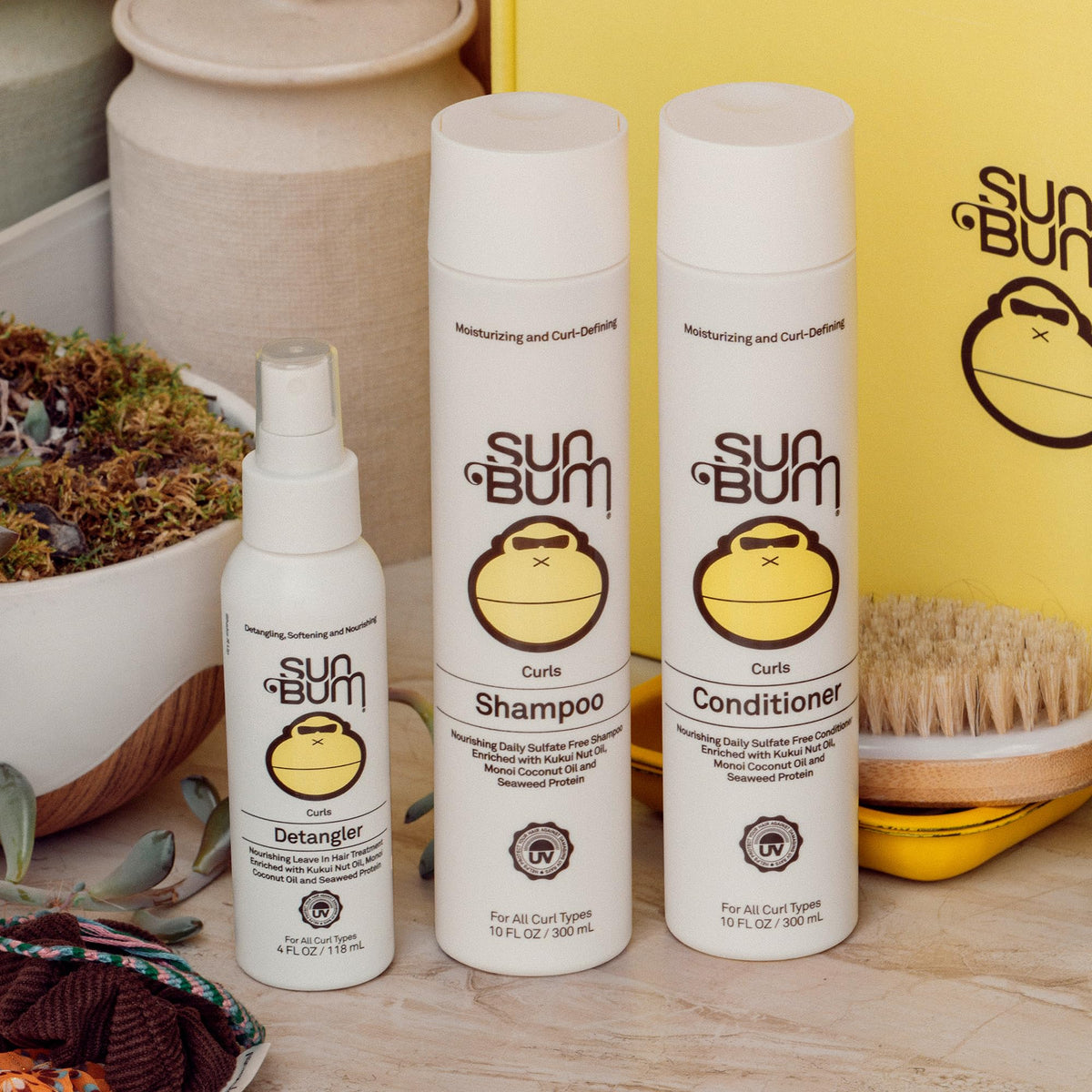 Close-up of Sun Bum formula on curly strand showing smoothing effect and added shine