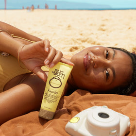 Sun Bum tube beside passport and sunglasses illustrating travel convenience
