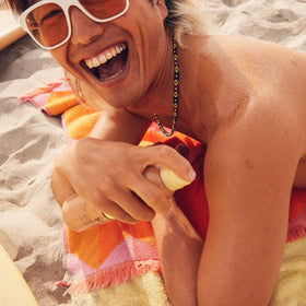 Sun Bum spray texture on forearm demonstrating quick-dry moisturizing benefit