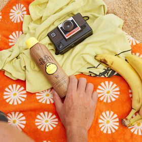 Sun Bum spray being applied to arm for quick even protection outdoors
