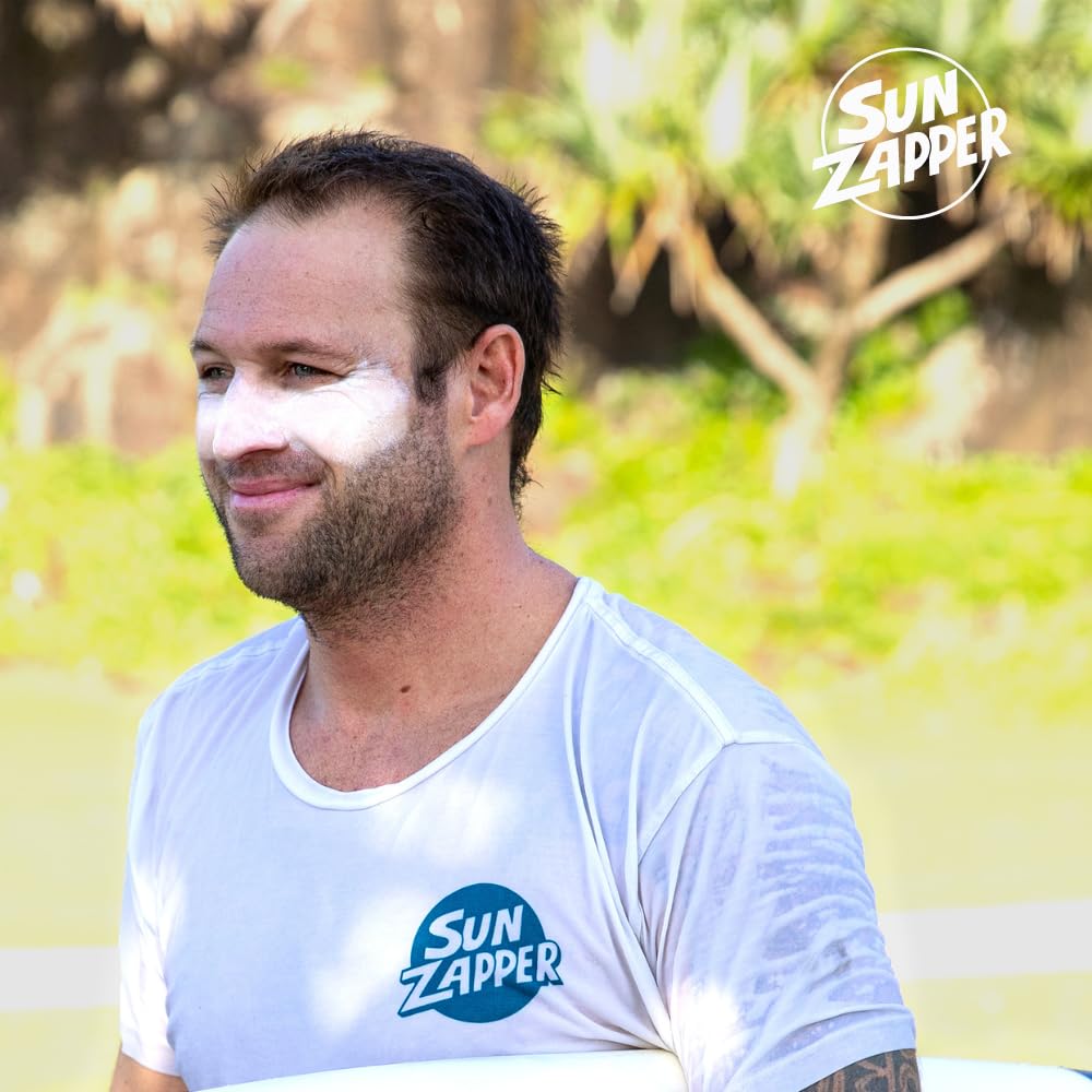 Surfer applying Sun Zapper on face before entering waves for long wear