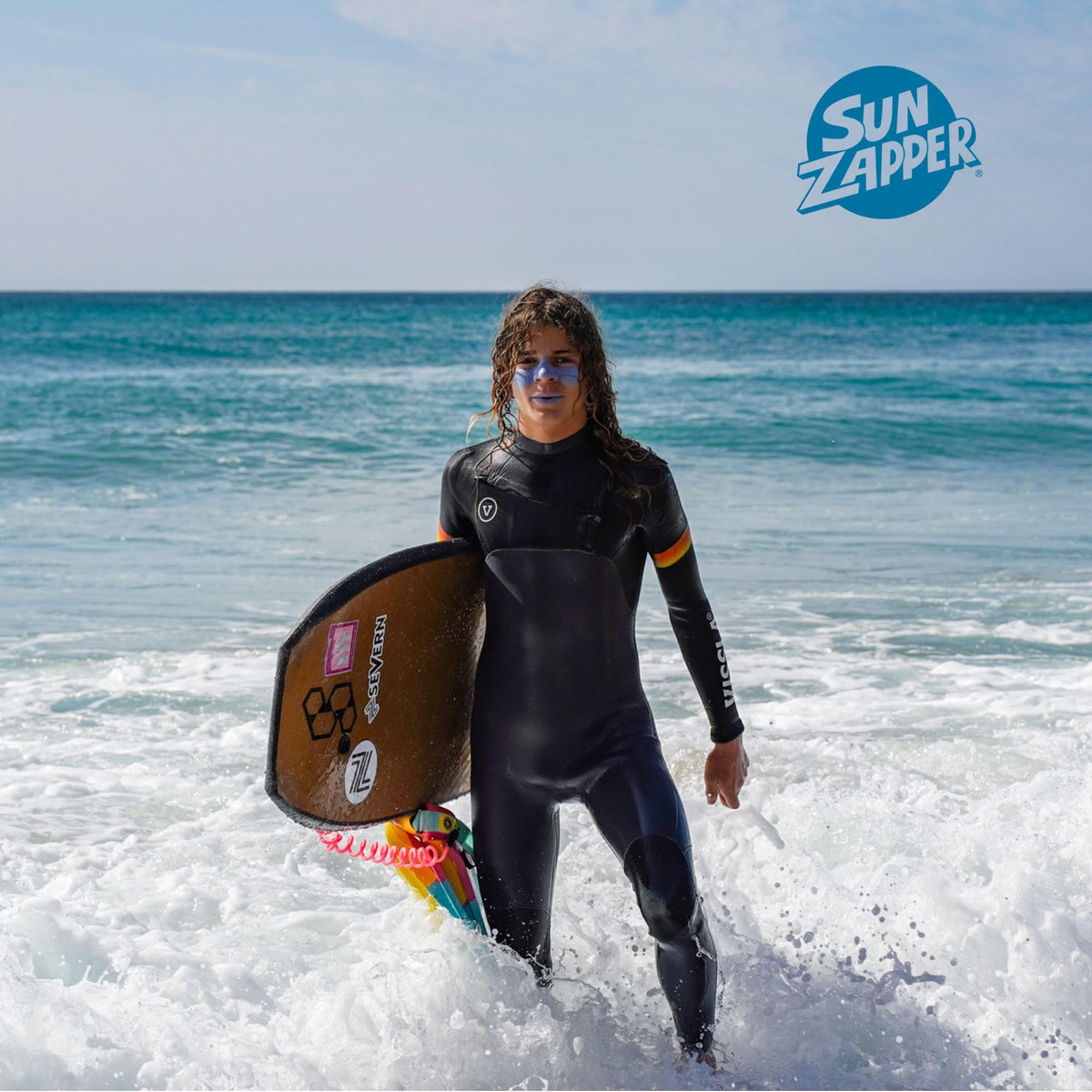 Surfer applying Sun Zapper before paddling showing rapid application benefit