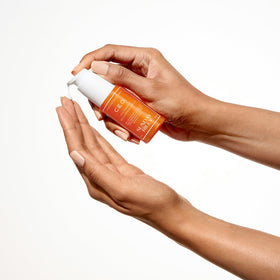 Sunday Riley bottle in hand to show 1.7oz scale and travel-friendly size