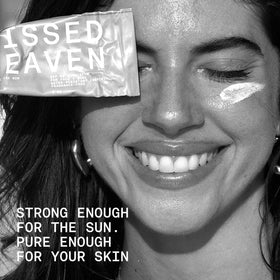 Sunkissed By Heaven jar on beach towel lifestyle scene showing real-world outdoor protection benefit
