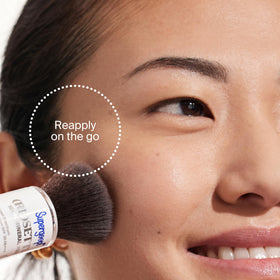 Supergoop! compact inside a handbag depicting on-the-go SPF reapplication