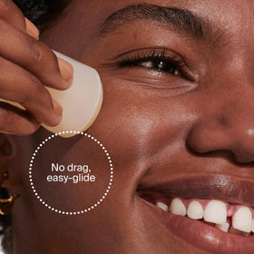 Supergoop! stick in hand to show compact 0.7 fl oz size and convenience