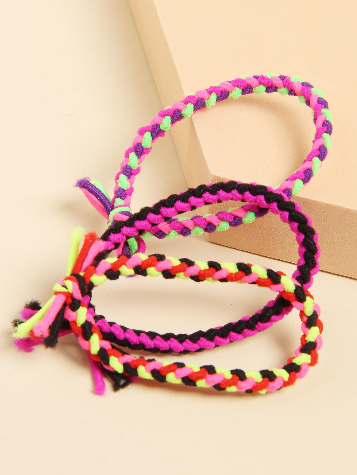 SUSULU hair tie next to a hand to show size and easy carrying benefit