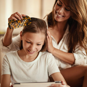 TaShow comb held in hand to show large size and ergonomic grip for comfortable styling