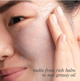 TATCHA balm melting on fingertip to a silky oil demonstrating easy warming and smooth application