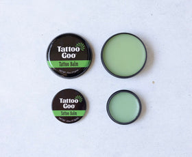 Tattoo Goo tins next to a smartphone showing scale and pocket-friendly travel convenience