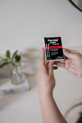 Tattoo Goo swab held in hand for scale showing compact, portable aftercare
