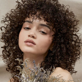 Tea Tree gel being scrunched into curly hair to enhance curls and reduce frizz