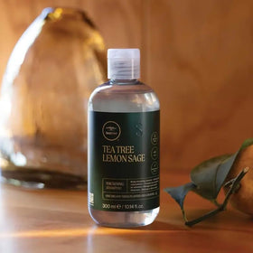 Tea Tree 2.5 fl oz bottle in palm illustrating compact travel-friendly size