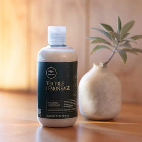 Tea Tree size comparison with hand to show 10.14 fl oz capacity and travel visibility