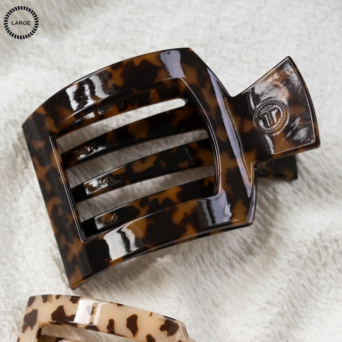 TELETIES clip next to a hand to show 4.1-inch size and scale benefit